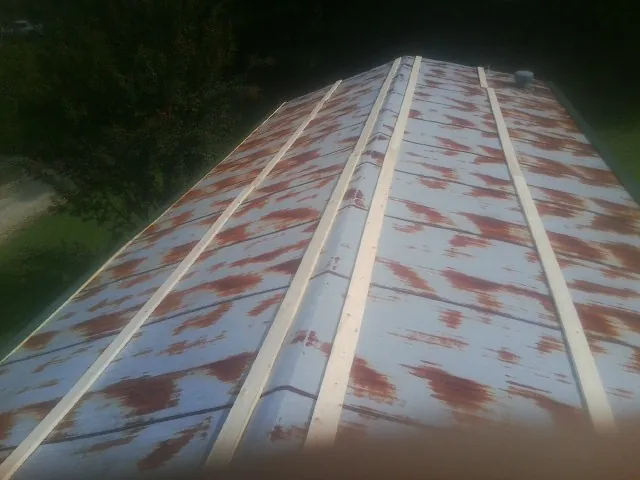 Rusted metal roof panels with new wood purlins before replacement — Storm Damage Roof Repair in Wakeman by Roofing Brothers