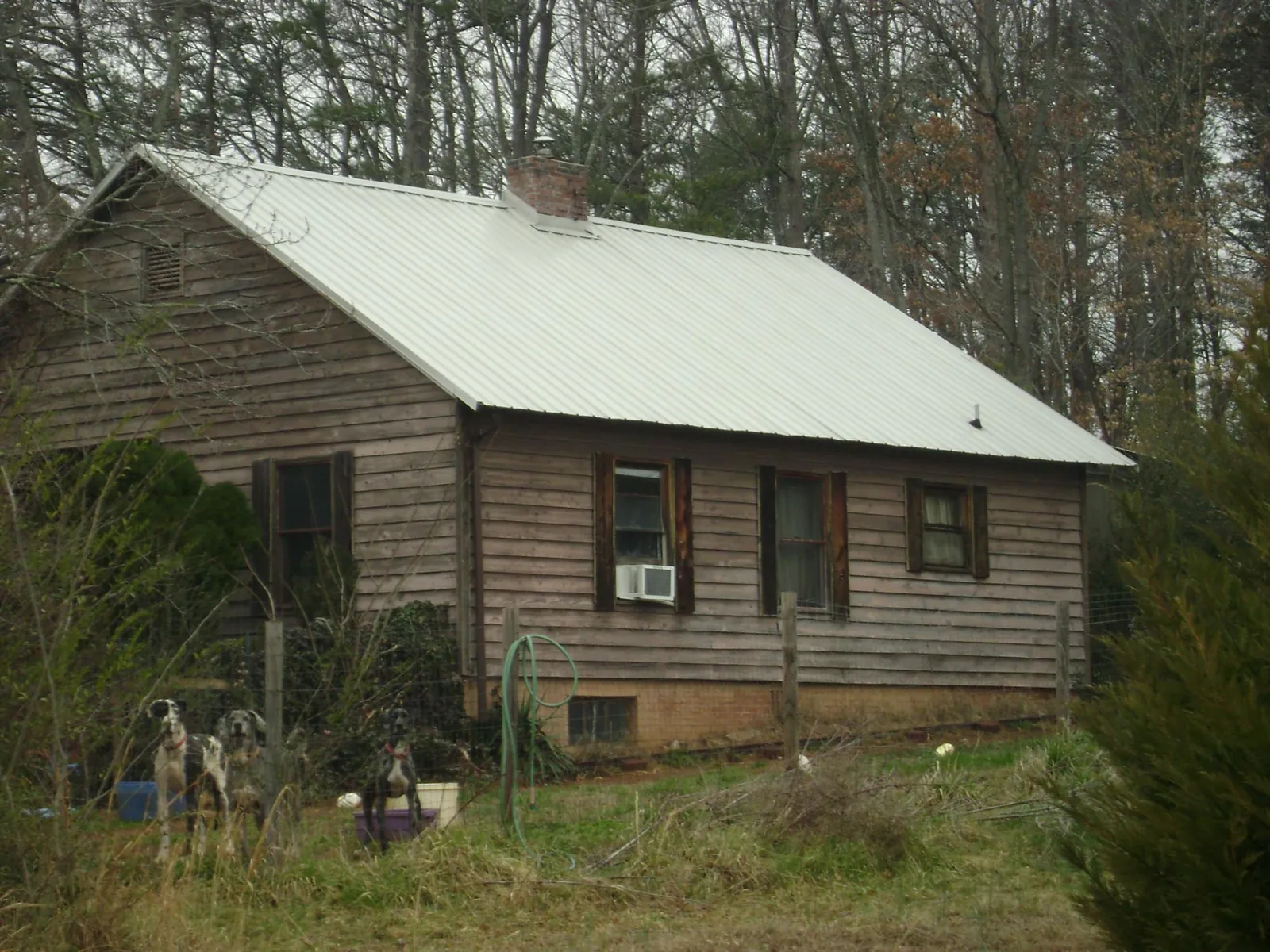 White metal roof on an old wood sided farmhouse, from a Metal Roof Installation job in Wakeman